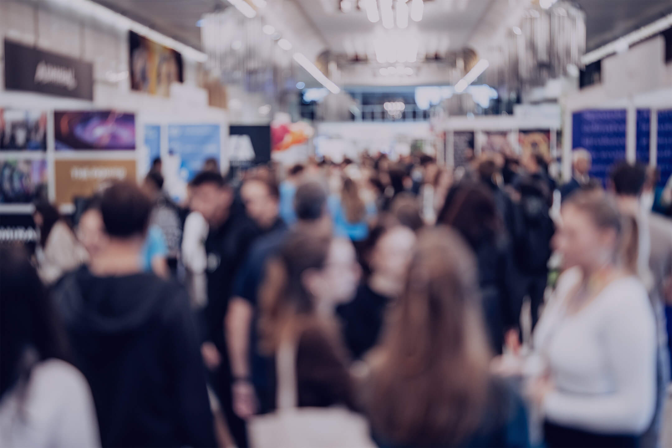 Foule de visiteurs dans les allées d'un salon professionnel dédié aux ressources humaines, avec des stands d'entreprises en arrière-plan.
